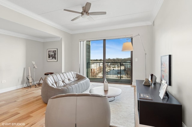 living room with hardwood / wood-style floors, crown molding, and ceiling fan