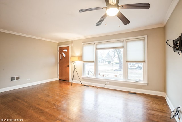 spare room featuring wood-type flooring, ornamental molding, and ceiling fan