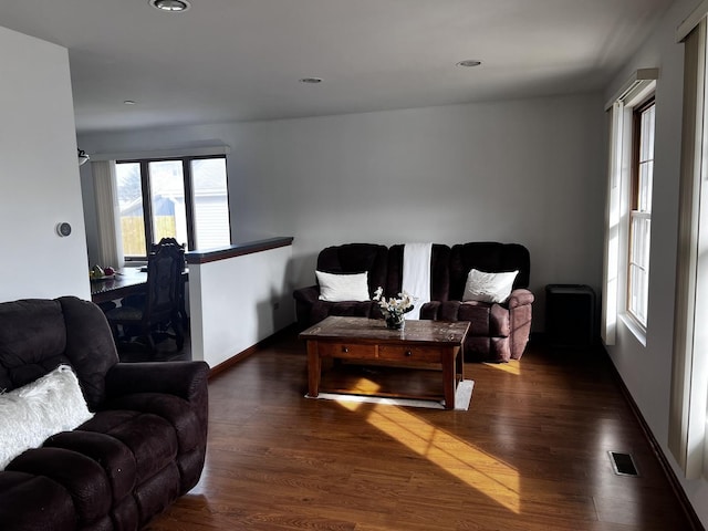 living room with a healthy amount of sunlight and dark hardwood / wood-style floors