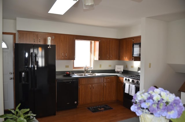 kitchen with ceiling fan, sink, dark hardwood / wood-style flooring, and black appliances