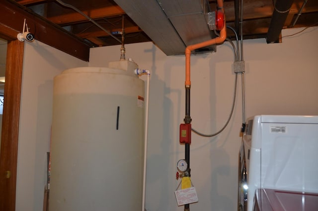 utility room featuring water heater and washer / dryer