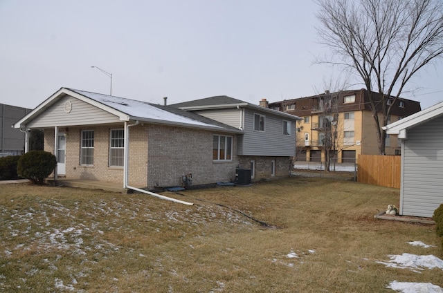 back of house with central AC and a lawn