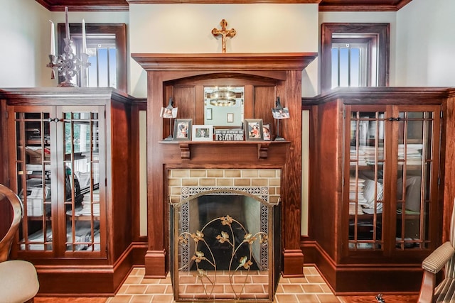 sitting room featuring light tile patterned floors, crown molding, and a fireplace