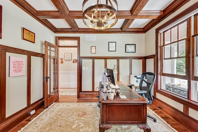 office space featuring beamed ceiling, coffered ceiling, ornamental molding, french doors, and a chandelier