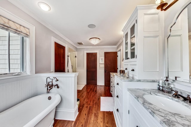 bathroom with vanity, ornamental molding, hardwood / wood-style flooring, and a tub