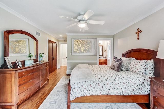 bedroom featuring ceiling fan, light wood-type flooring, connected bathroom, ornamental molding, and a closet