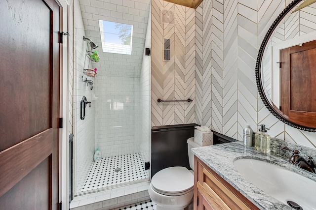 bathroom featuring tile walls, toilet, a shower with door, and vanity