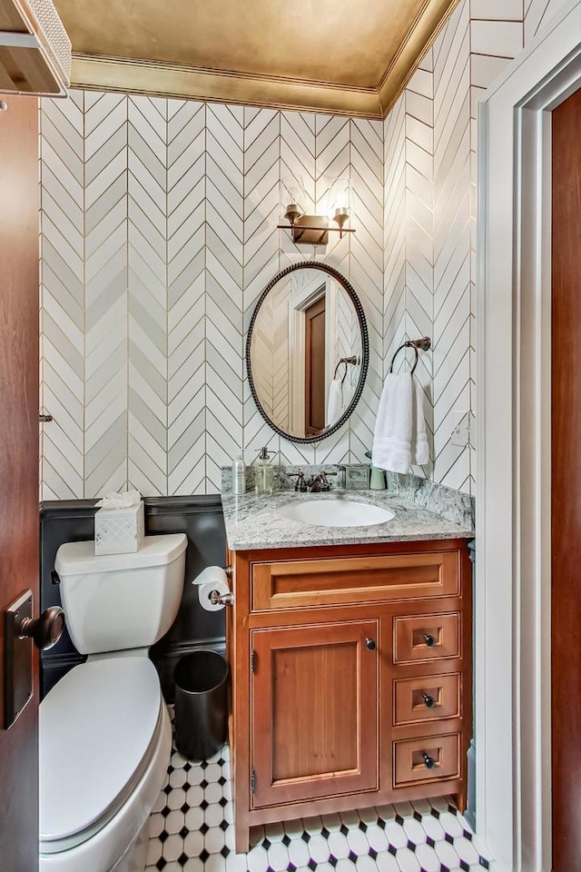 bathroom featuring toilet, vanity, and crown molding