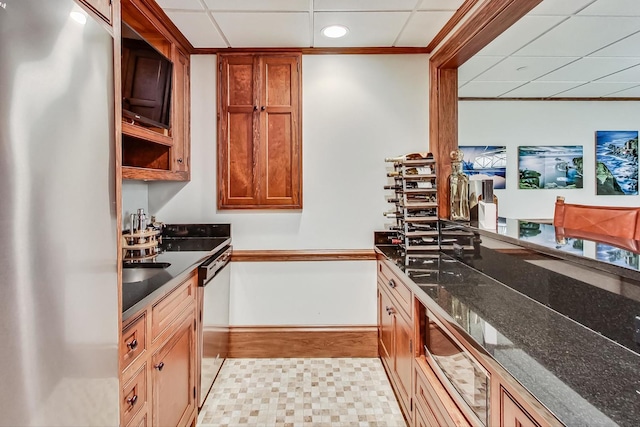 kitchen featuring a paneled ceiling, dark stone countertops, refrigerator, and dishwasher