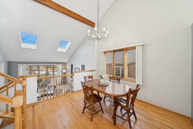 dining area featuring an inviting chandelier, a skylight, high vaulted ceiling, light hardwood / wood-style flooring, and beamed ceiling