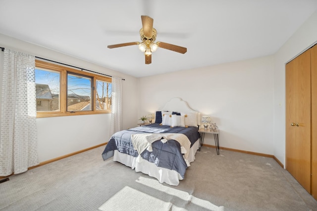 bedroom featuring light colored carpet, ceiling fan, and a closet