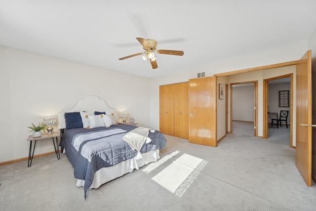 bedroom featuring light carpet, ceiling fan, and a closet