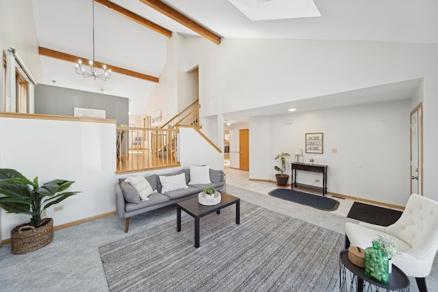 living room featuring a skylight, high vaulted ceiling, a chandelier, beamed ceiling, and light colored carpet