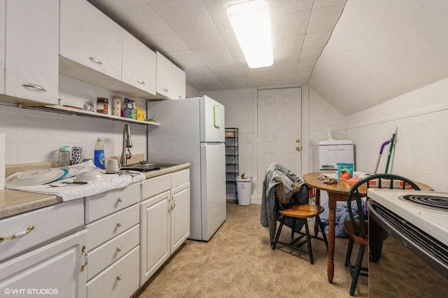 kitchen with lofted ceiling, white cabinets, sink, and white appliances