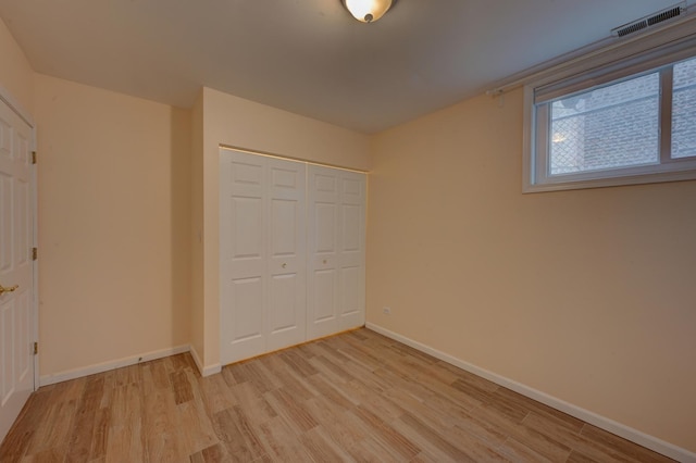 unfurnished bedroom featuring light hardwood / wood-style floors and a closet