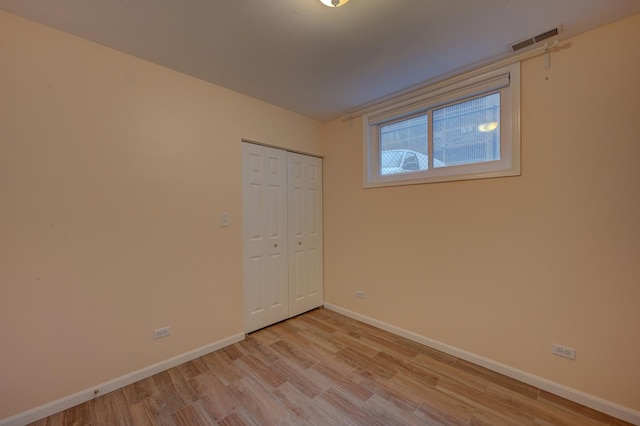 unfurnished bedroom with a closet and light hardwood / wood-style floors