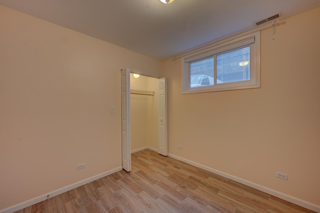 unfurnished bedroom with a closet and light hardwood / wood-style flooring