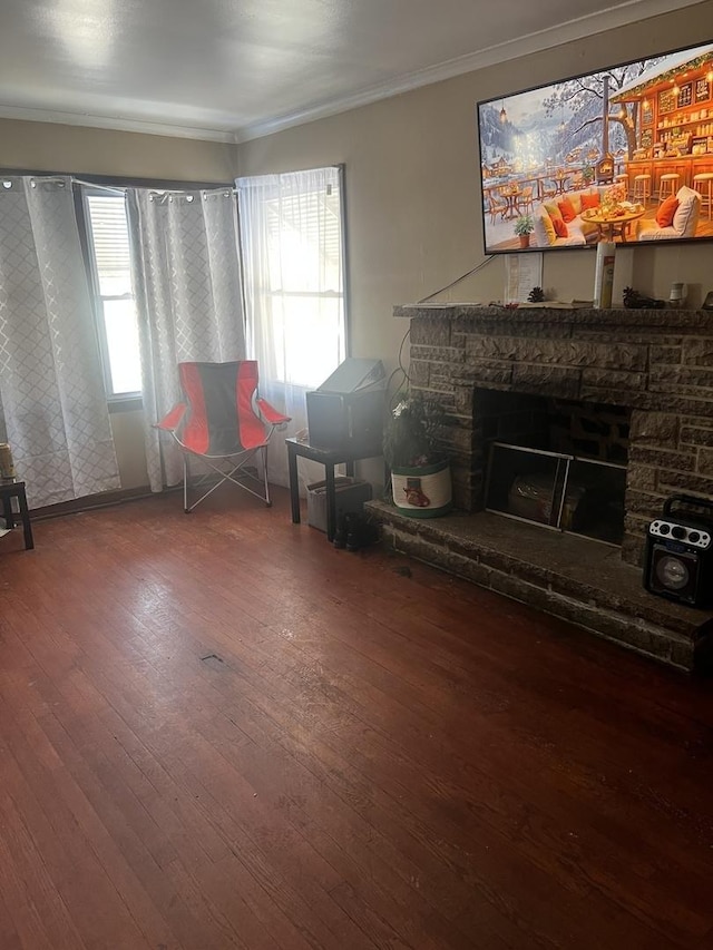 interior space with crown molding, hardwood / wood-style flooring, and a stone fireplace