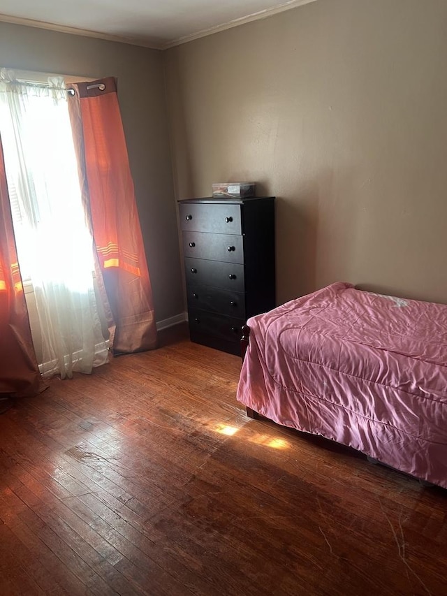 unfurnished bedroom with ornamental molding and dark hardwood / wood-style floors