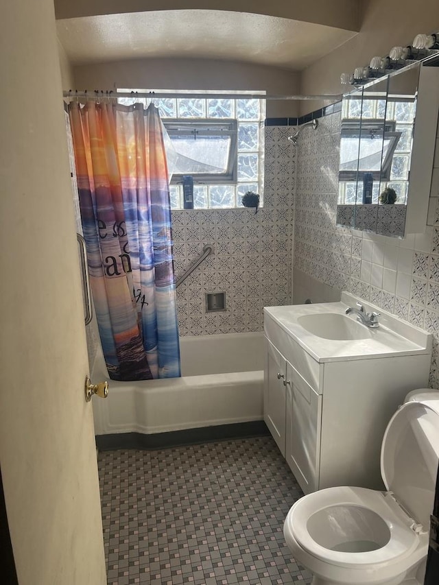 full bathroom featuring vanity, toilet, shower / bath combination with curtain, and tile walls