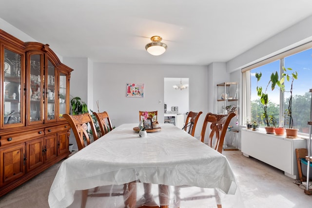 carpeted dining room featuring an inviting chandelier