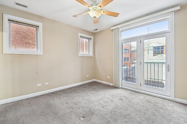 empty room featuring ceiling fan and carpet