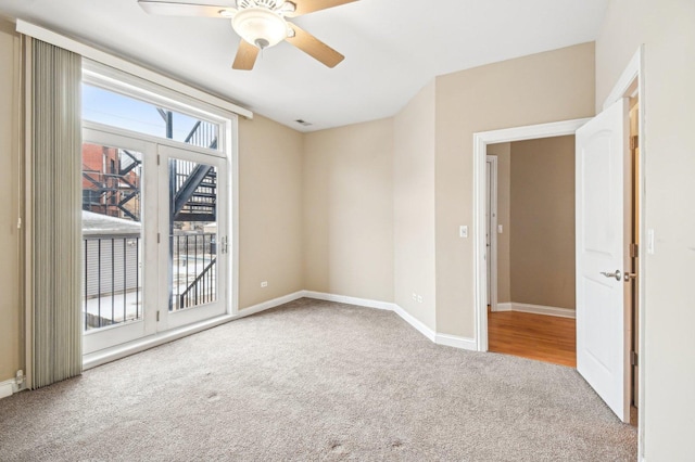 empty room with ceiling fan and light carpet