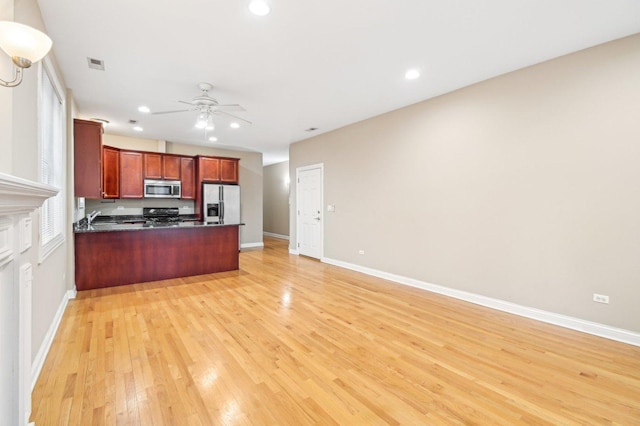 kitchen featuring appliances with stainless steel finishes, kitchen peninsula, ceiling fan, and light hardwood / wood-style floors