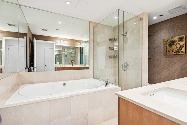 bathroom featuring vanity and independent shower and bath