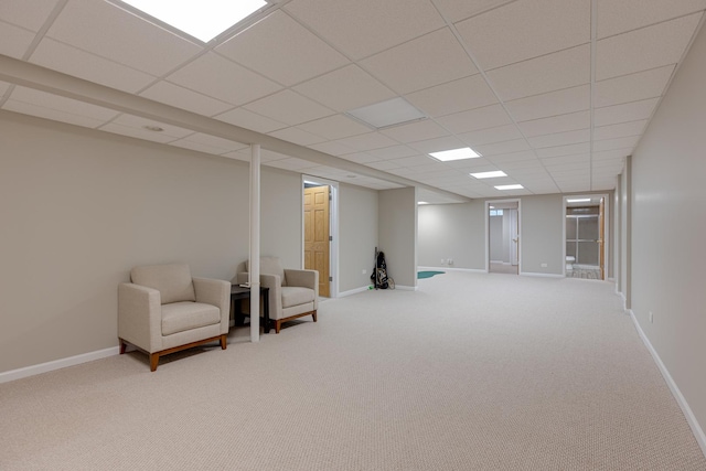 sitting room featuring carpet and a drop ceiling