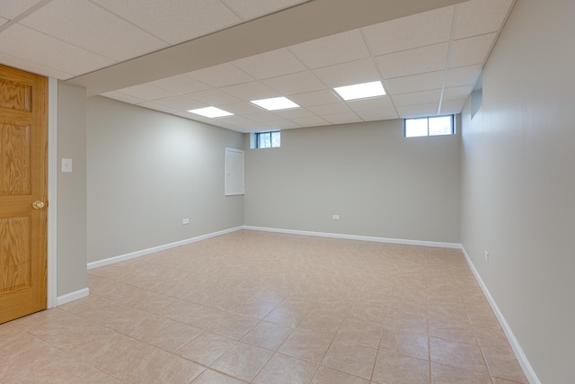 basement with a paneled ceiling and light tile patterned floors