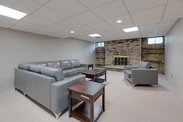 living room with a brick fireplace, light carpet, and a paneled ceiling