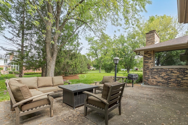 view of patio with an outdoor living space with a fire pit