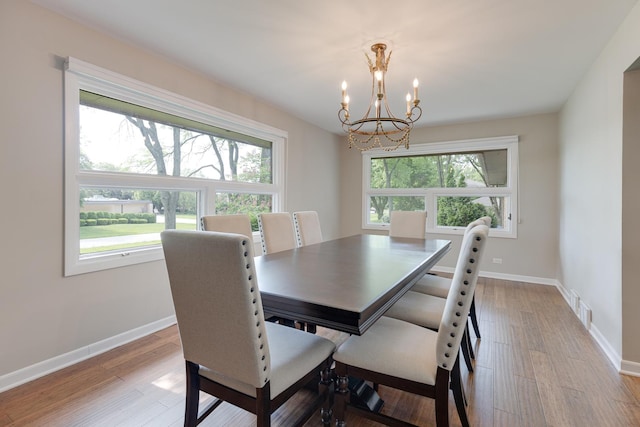 dining space with a notable chandelier and light wood-type flooring