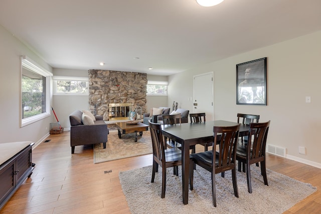 dining room featuring a fireplace and light wood-type flooring