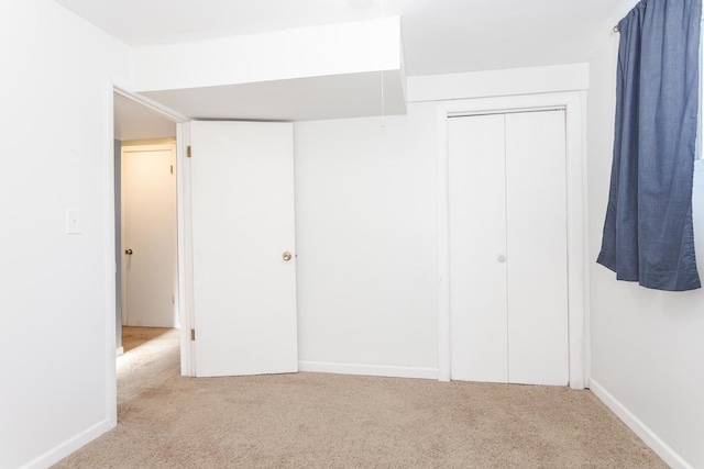 unfurnished bedroom with a closet and light carpet