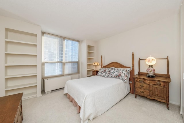 bedroom with radiator and light carpet