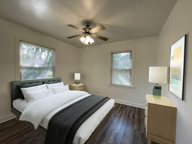 bedroom featuring ceiling fan, dark wood-type flooring, and multiple windows