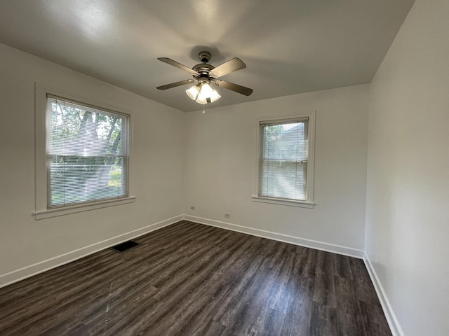 unfurnished room featuring ceiling fan, a healthy amount of sunlight, and dark hardwood / wood-style floors