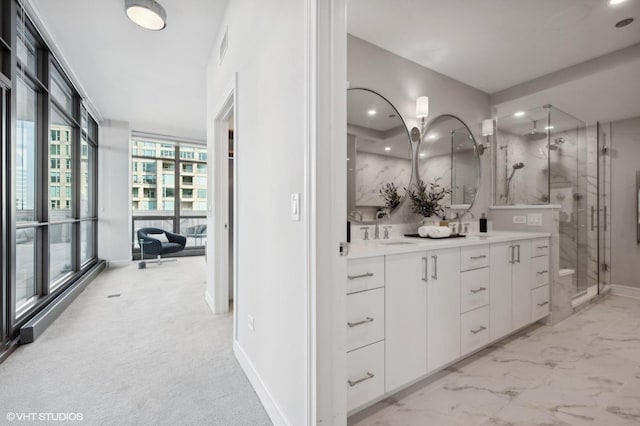 bathroom featuring a wall of windows, an enclosed shower, and vanity