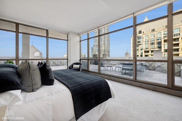 carpeted bedroom featuring floor to ceiling windows and multiple windows