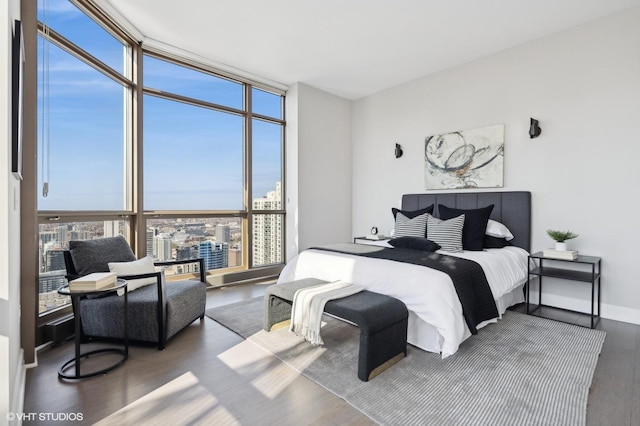 bedroom with expansive windows and dark hardwood / wood-style flooring