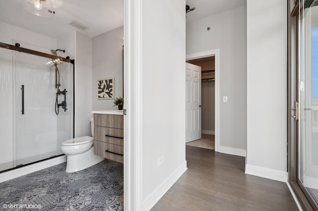 bathroom with walk in shower, vanity, and toilet