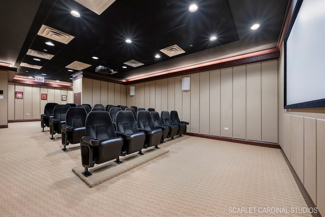 home theater room with light carpet and a raised ceiling