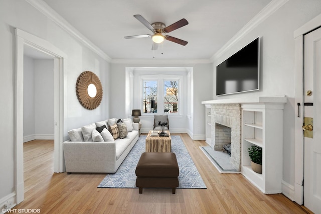 living room featuring ornamental molding, a brick fireplace, ceiling fan, and light hardwood / wood-style floors