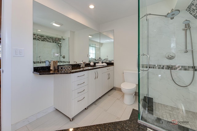 bathroom with vanity, tile patterned floors, a shower with door, and toilet