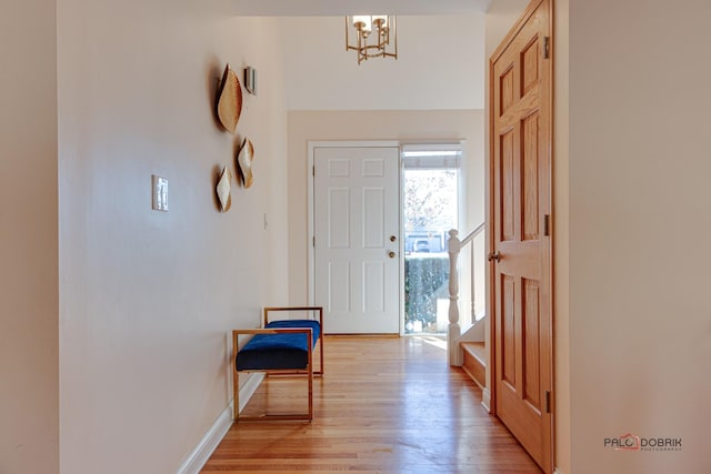 foyer entrance with a notable chandelier and light wood-type flooring