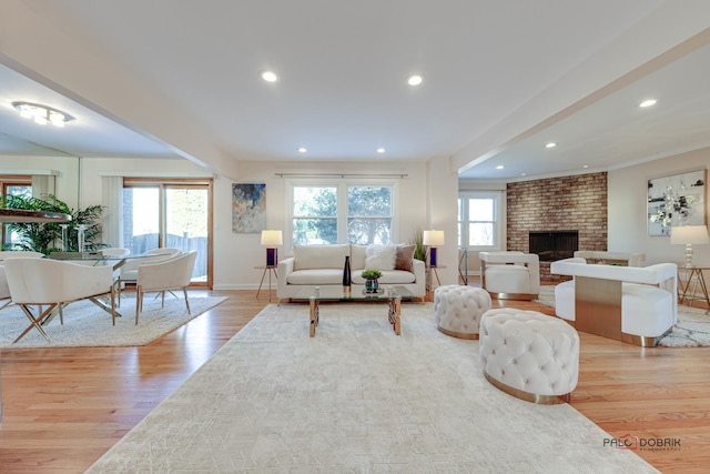 living room with a brick fireplace and light hardwood / wood-style floors