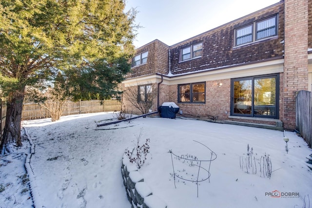 view of snow covered back of property