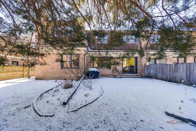 view of snow covered back of property